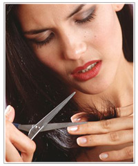 Woman cutting ends of hair.